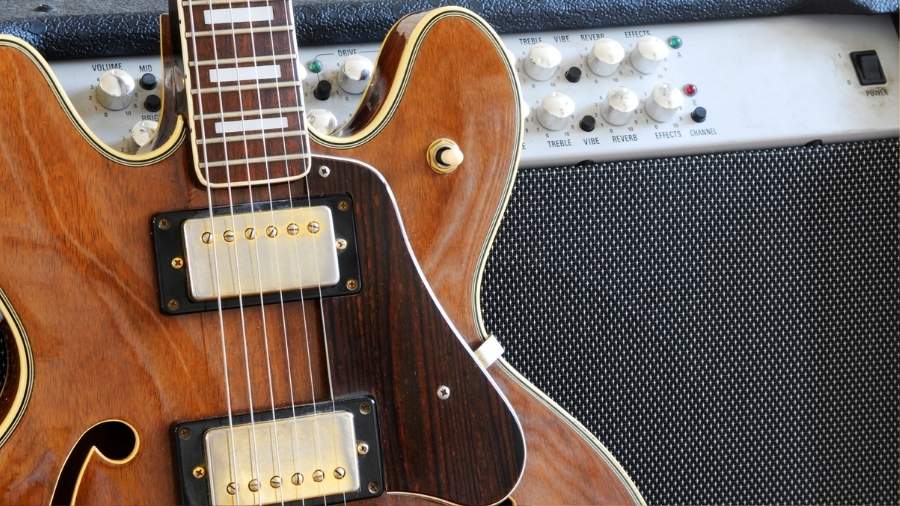 Solid Electric Guitar in front of a guitar amp