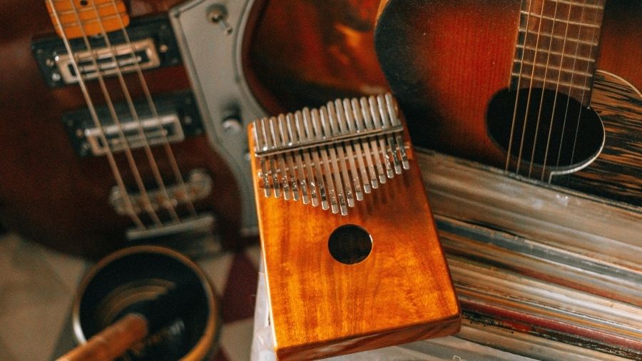 A kalimba surrounded by an acoustic guitar and an electric guitar, arranged together as musical instruments.