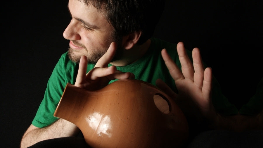 Man playing the traditional clay Nigerian clay drum