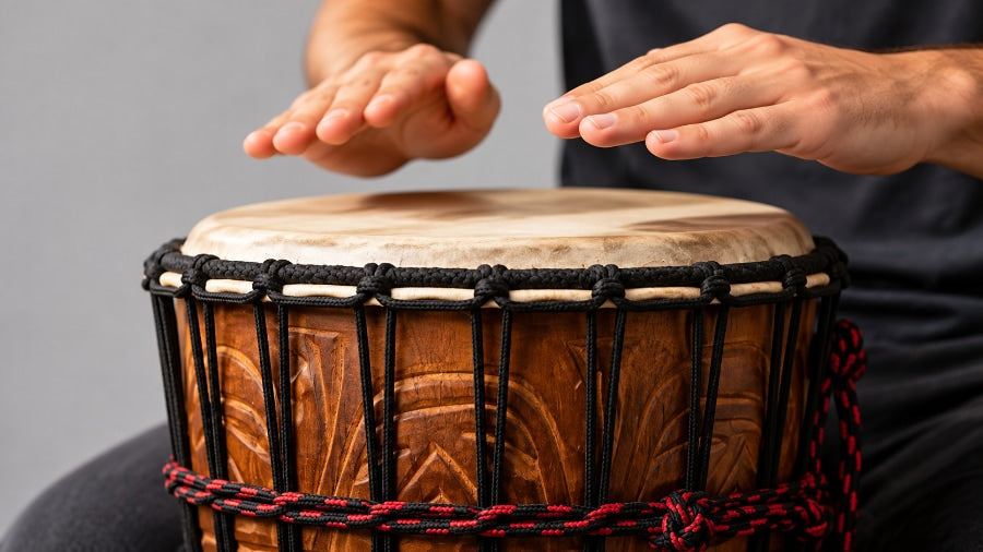 Hands playing a djembe drum in a studio