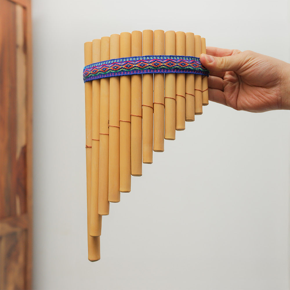 13-note Peruvian siku bamboo panpipes held in hand to show scale. Traditional woodwind pan flute.