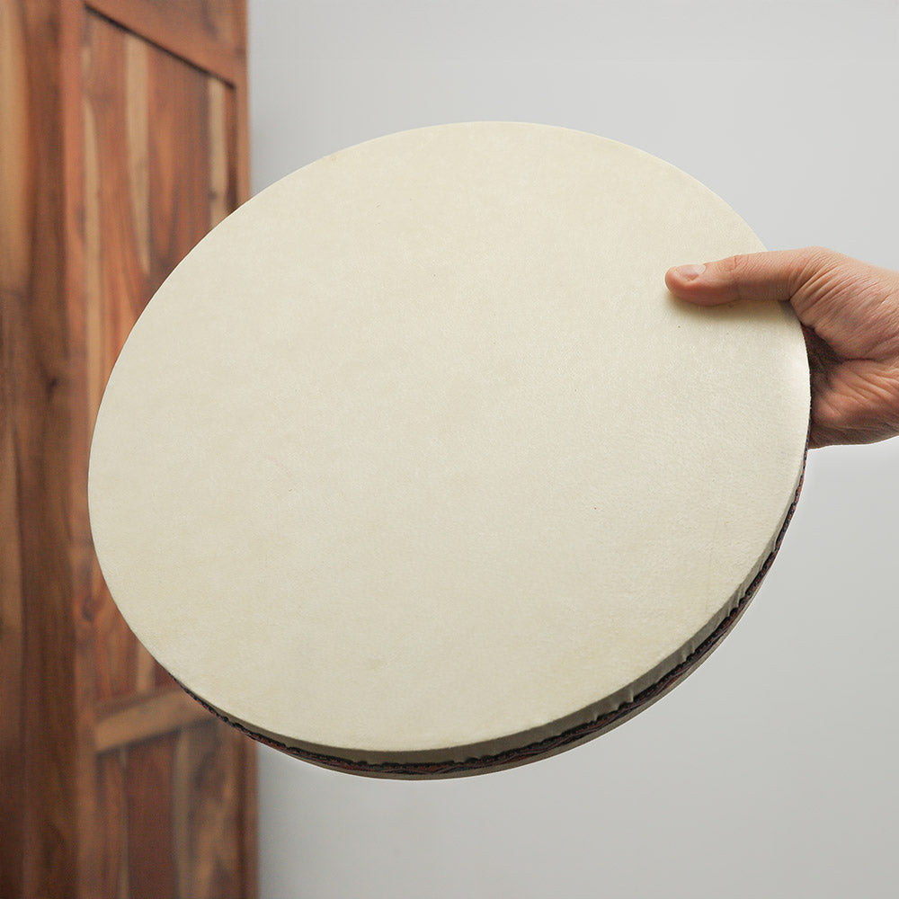 14-inch Besar Ocean Drum with black ribbon held in hand to show scale and size.