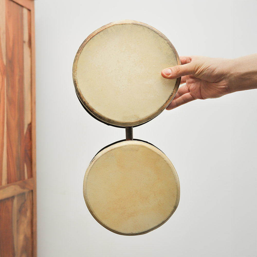 African Ngoma drums held in hand, showcasing their size and design.