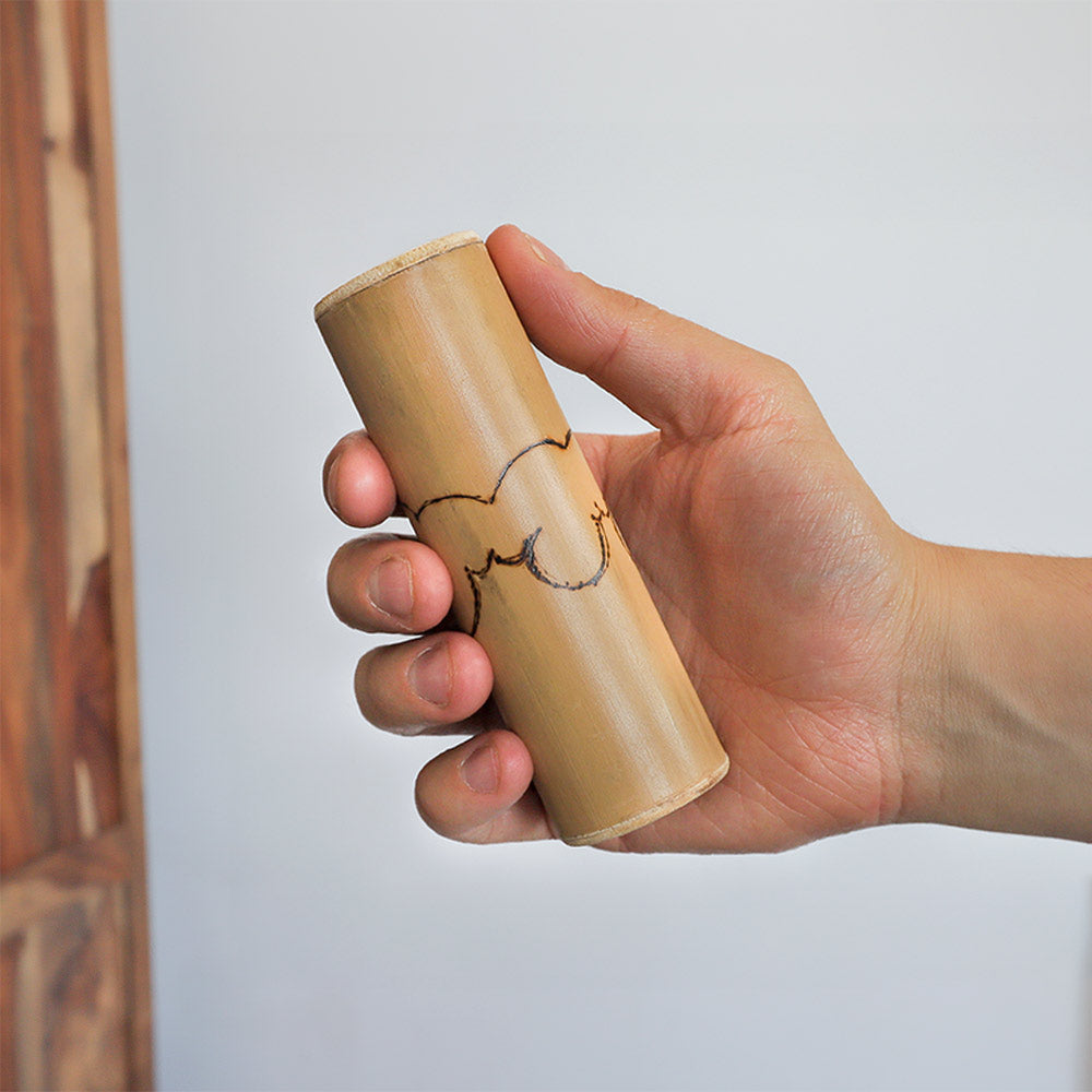 Bamboo Jati shaker instrument held in the hand to show scale size/