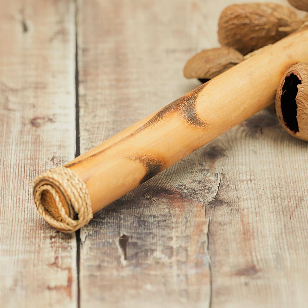 Close-up of the Bamboo Raha Stick Shaker handle, highlighting its abstract design and smooth finish.