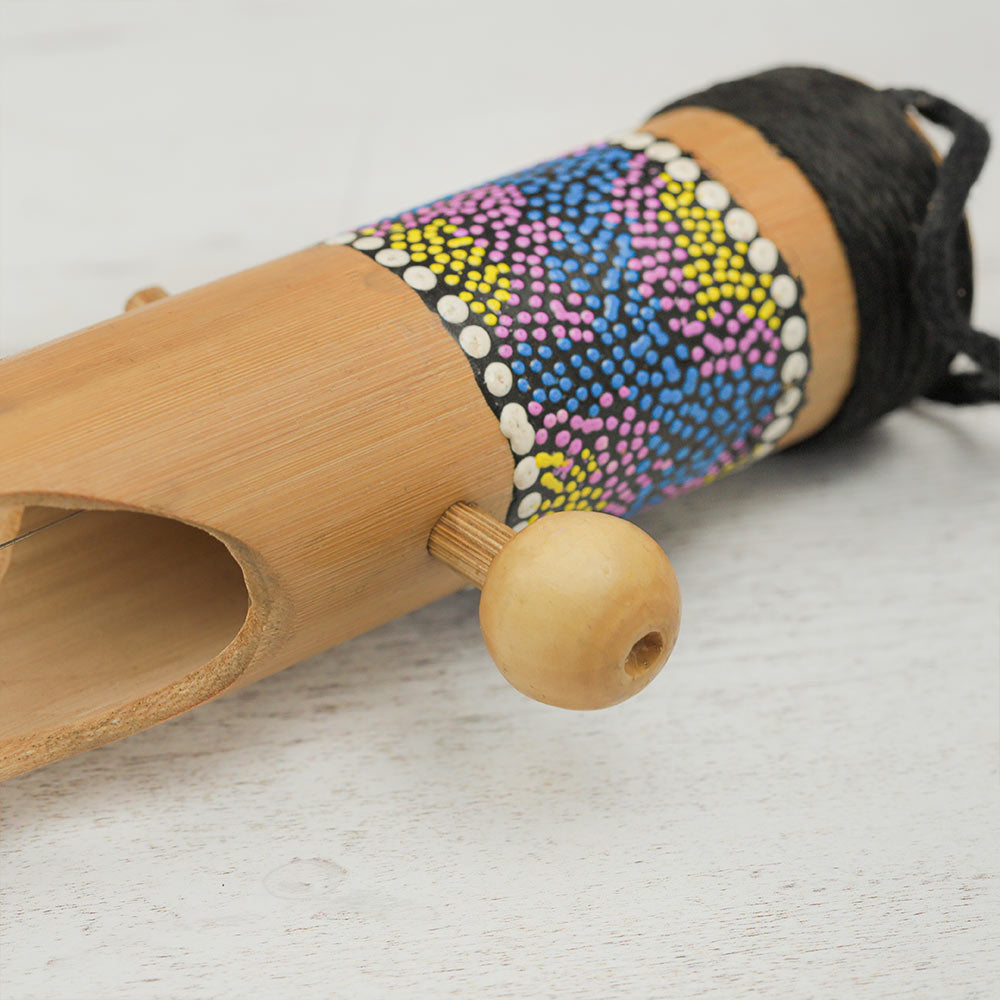 Close-up of the top of the Begijen stringed instrument showing the wooden tuning peg and purple dot painted design.