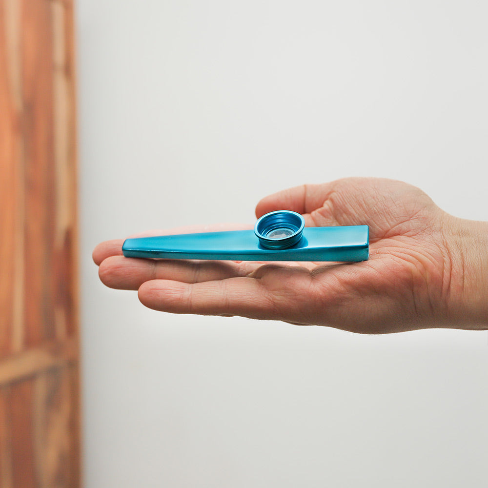 Blue Hechi kazoo held in hand, demonstrating its size and sleek design.