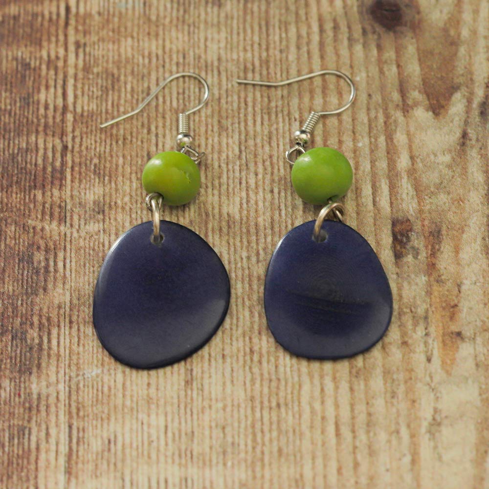 Blue and green Tagua earrings on a wooden backdrop