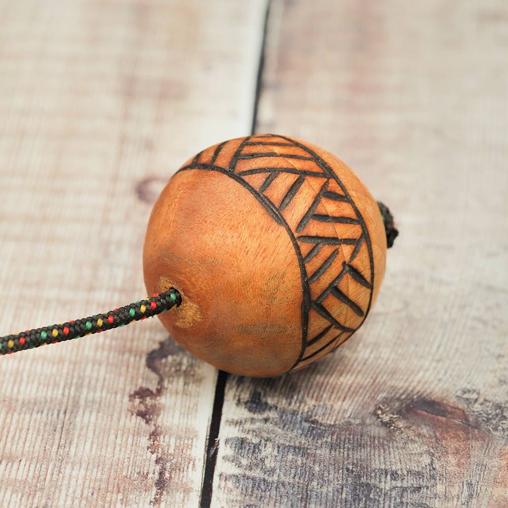 Top view of the wooden Kashaka shaker showing the knot where the rope is secured into the cas ball.
