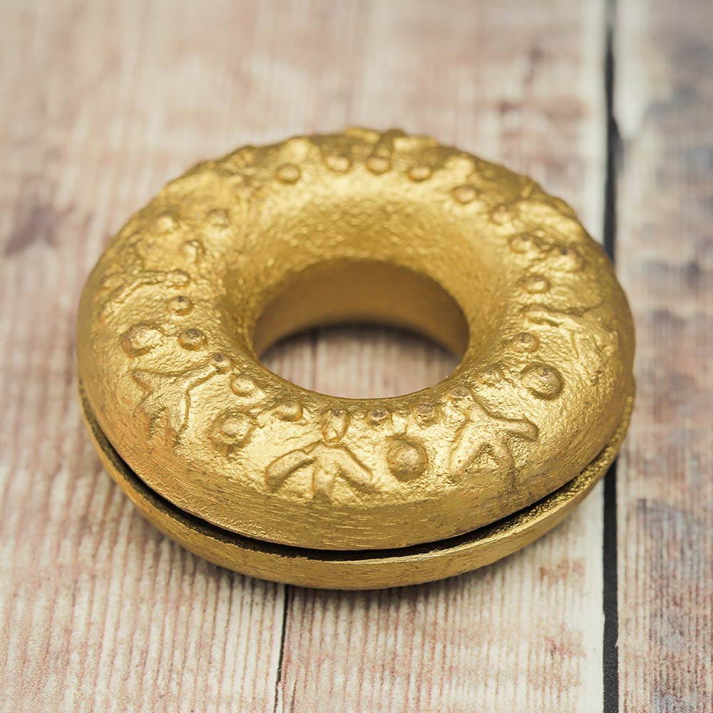 Top of the Brass Meo finger bell displaying intricate symbols.