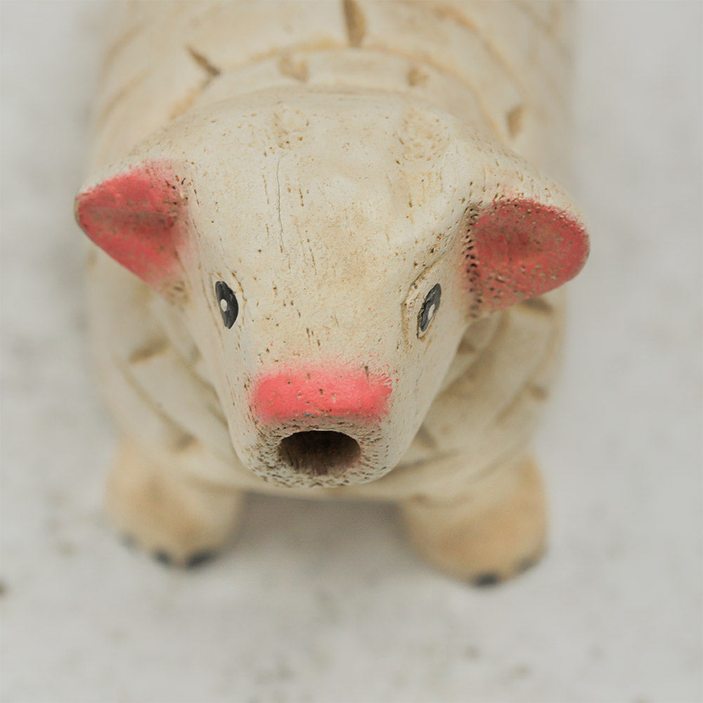Close-up of the wooden sheep whistle, highlighting the carved face details.