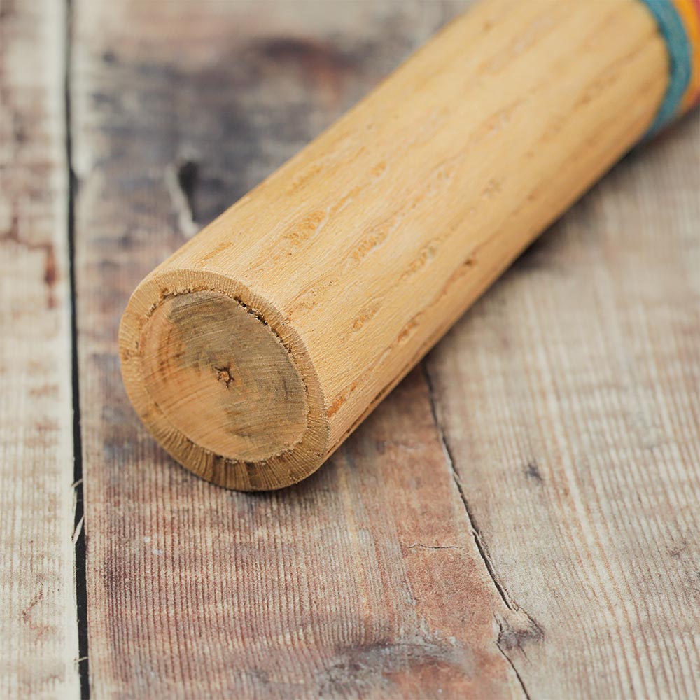 Detailed view of the cactus rainstick's end, showcasing its natural spiky texture and the hollowed interior used for creating rain-like sounds.