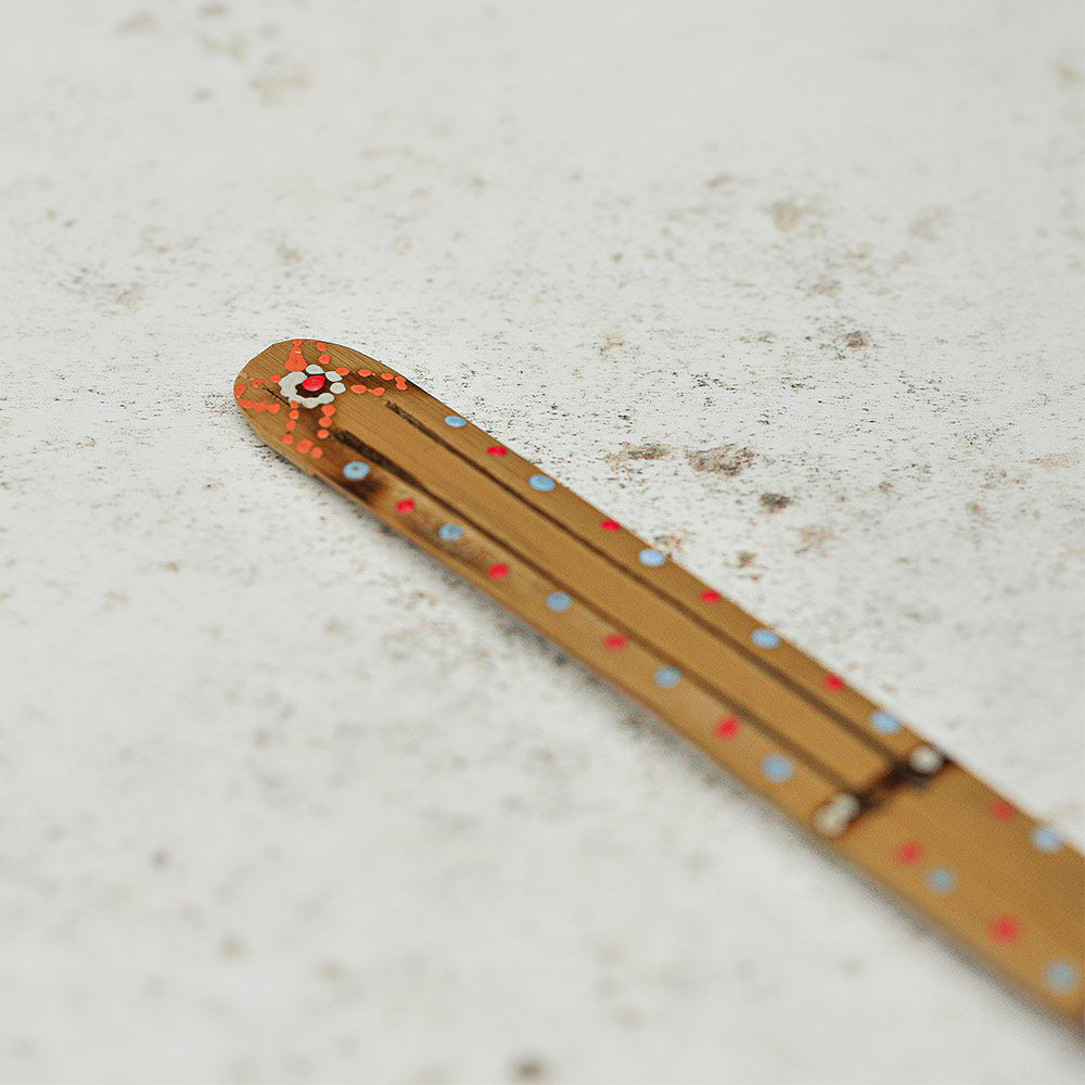 Close-up of the Karinding jaw harp, showcasing its intricate painted design.