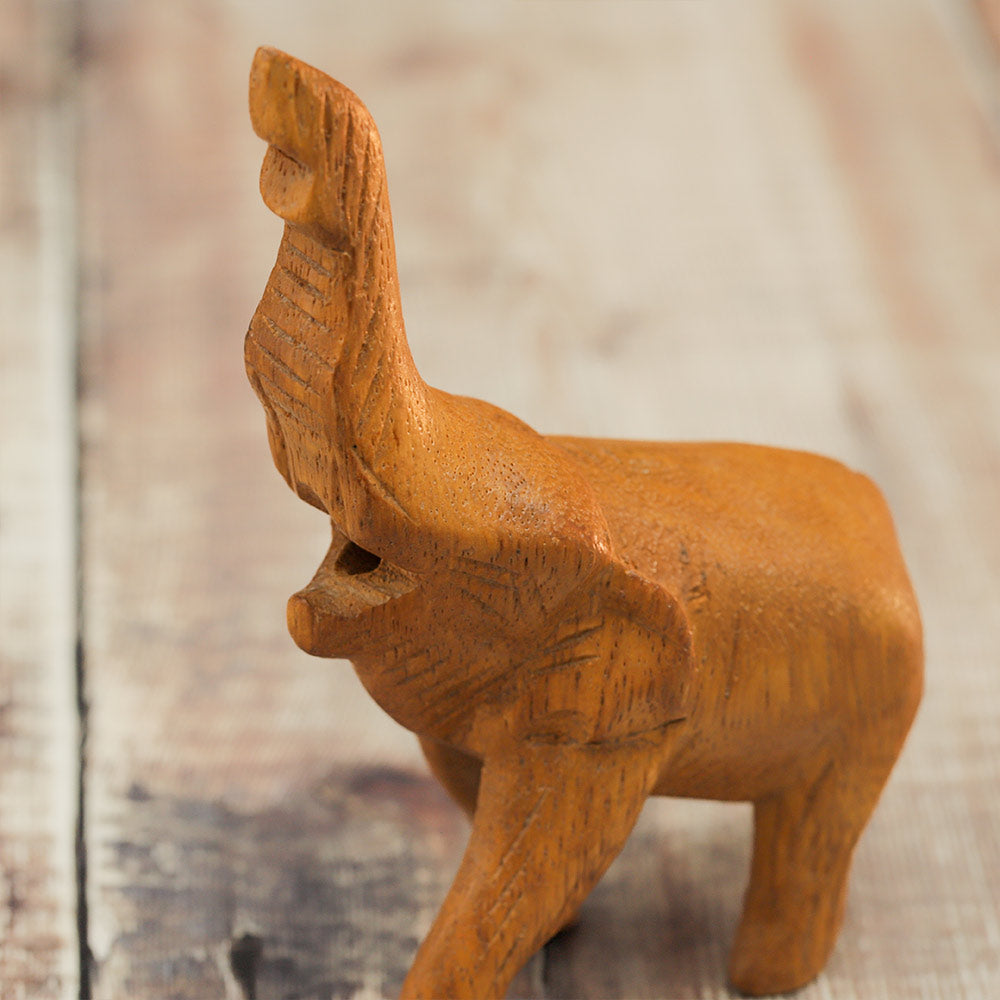 Close-up of the carved face of the wooden Noisy Elephant Whistle ornament, showcasing its intricate details.