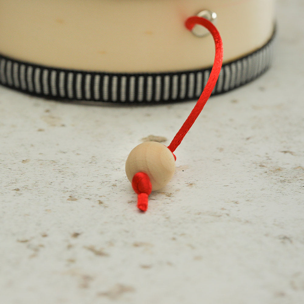Close up of the adesu monkey drum ball striker with red string attached