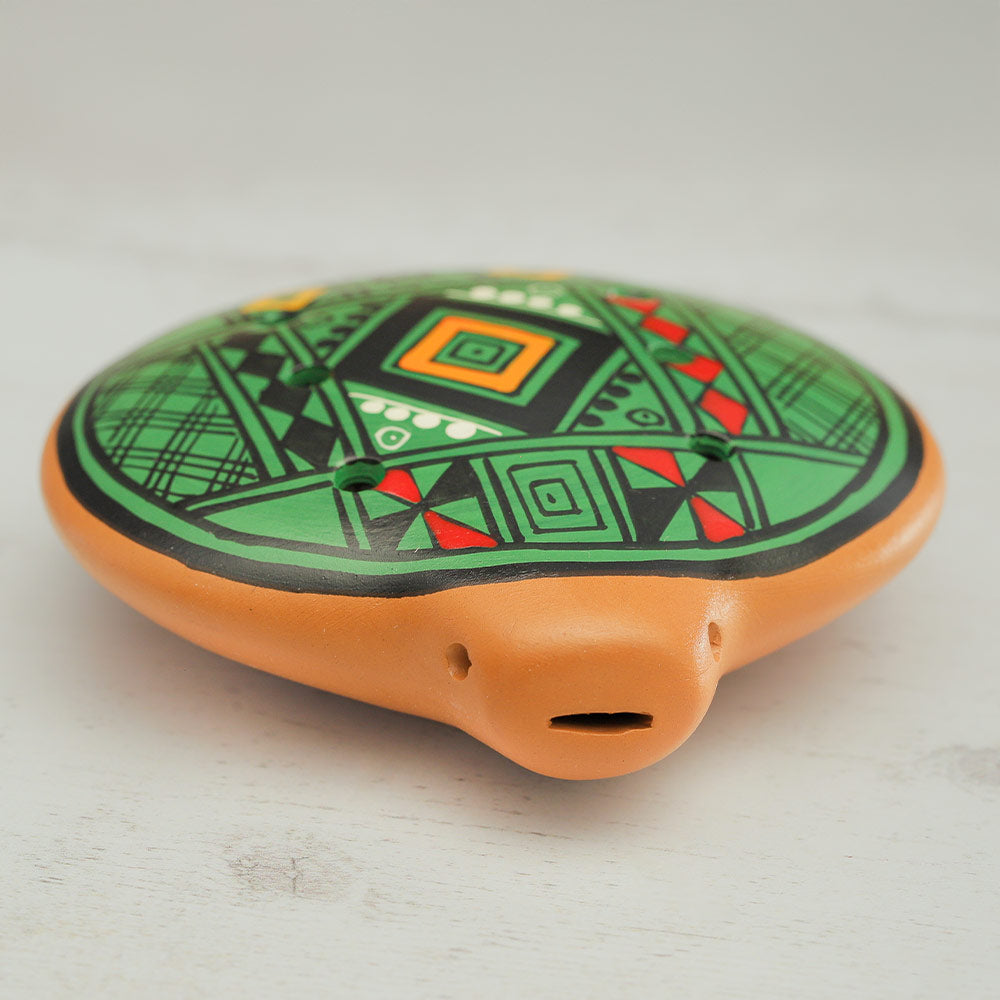 Top of the clay inca ocarina sowing geometric painted design and clay mouth piece