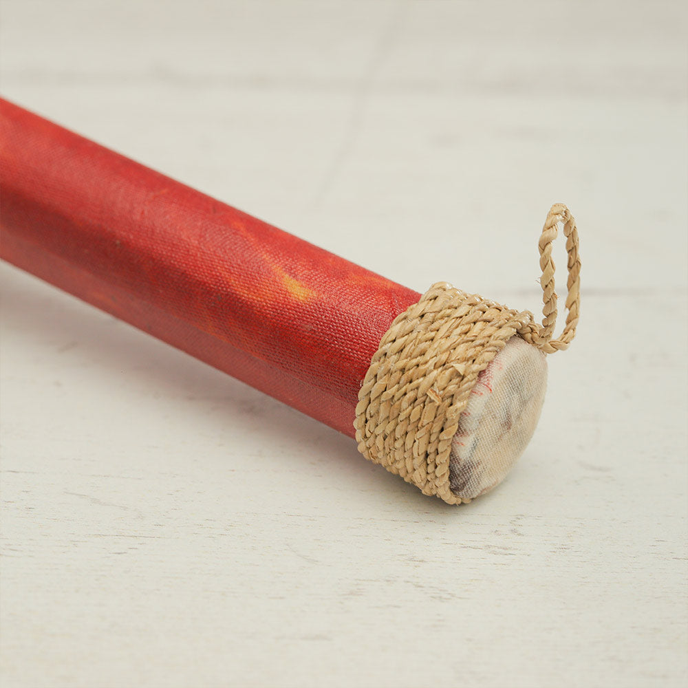 Close up of the rubber seed shaker handle wrapped with rattan to create a loop on a professional backdrop