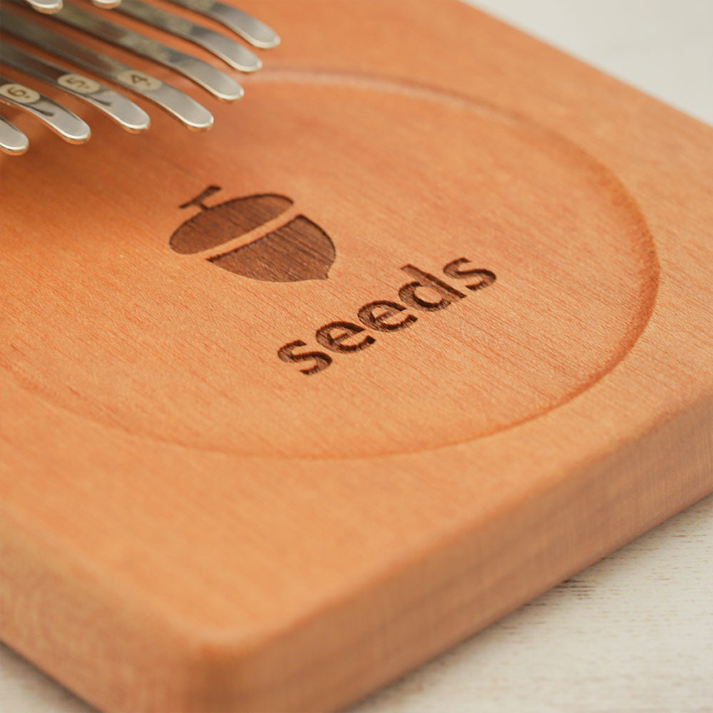 Close up of the seeds logo on the board kalimba