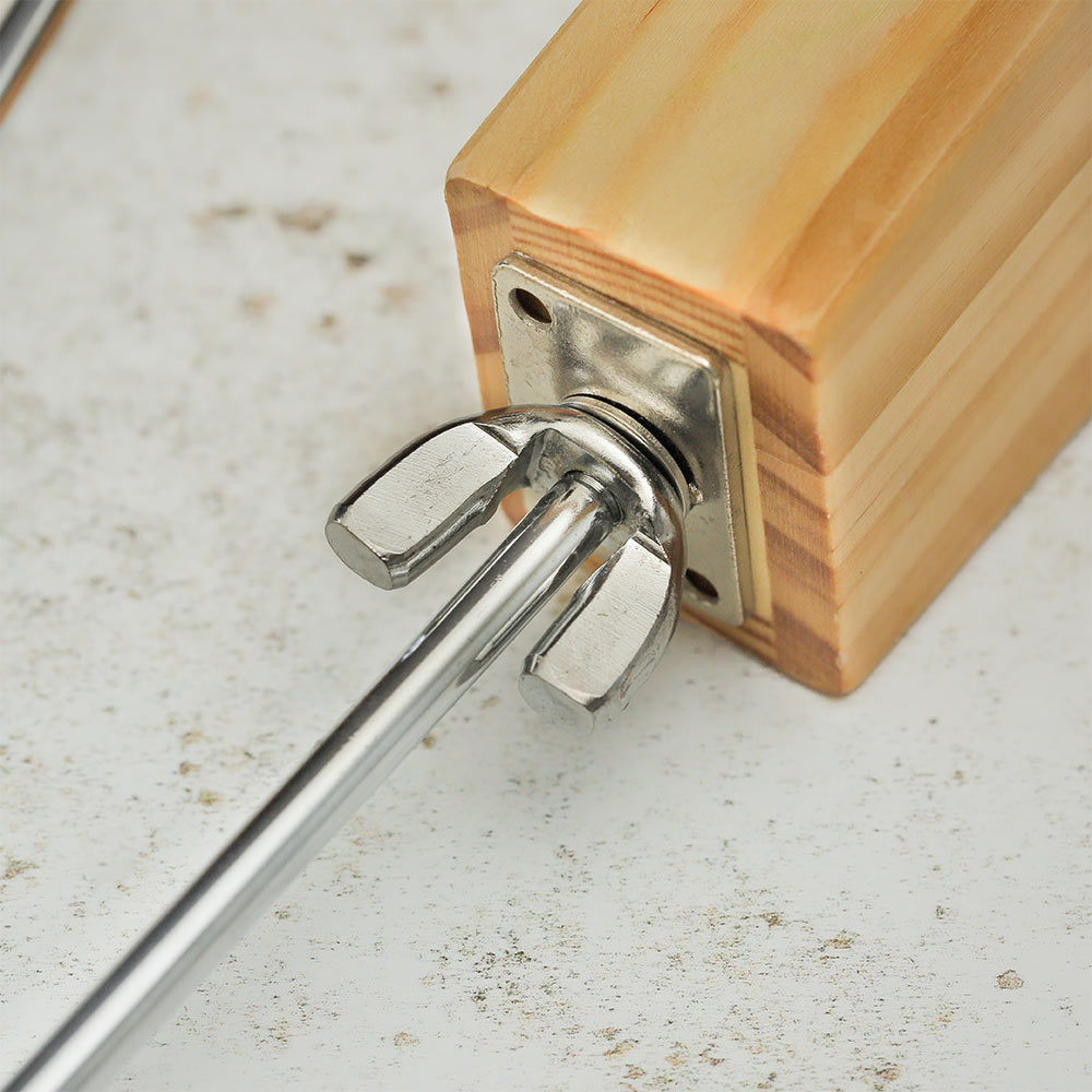 Extreme close-up of the metal tightening bolt on a Vibraslap instrument, showing its smooth metal surface and attachment point.