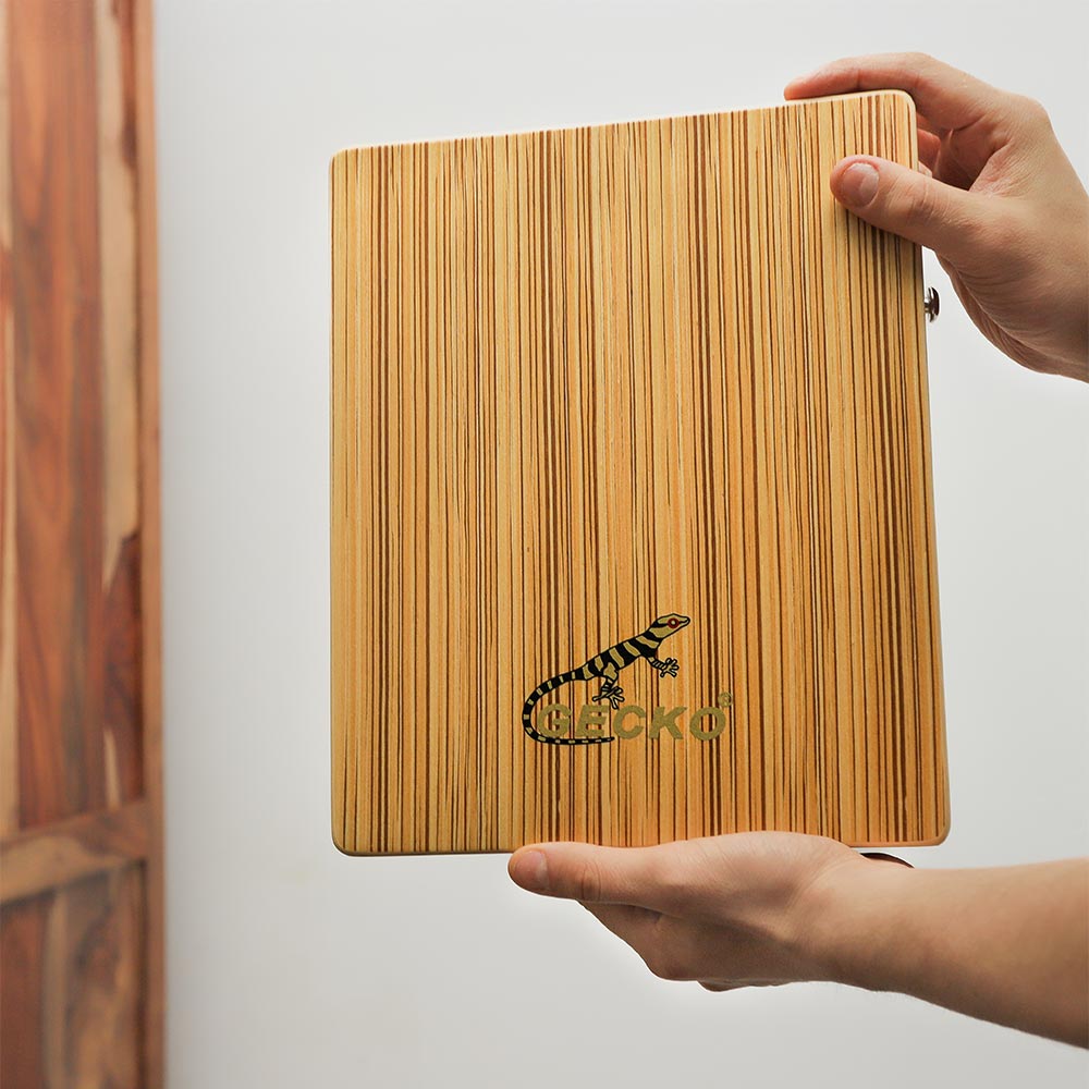 Gecko cajon held in hand, showing its size and close-up of the design and logo.