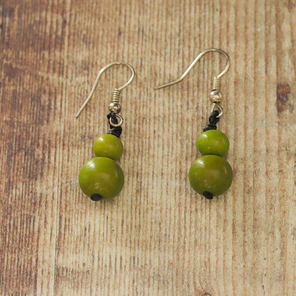 Green Tagua earrings on a wooden backdrop