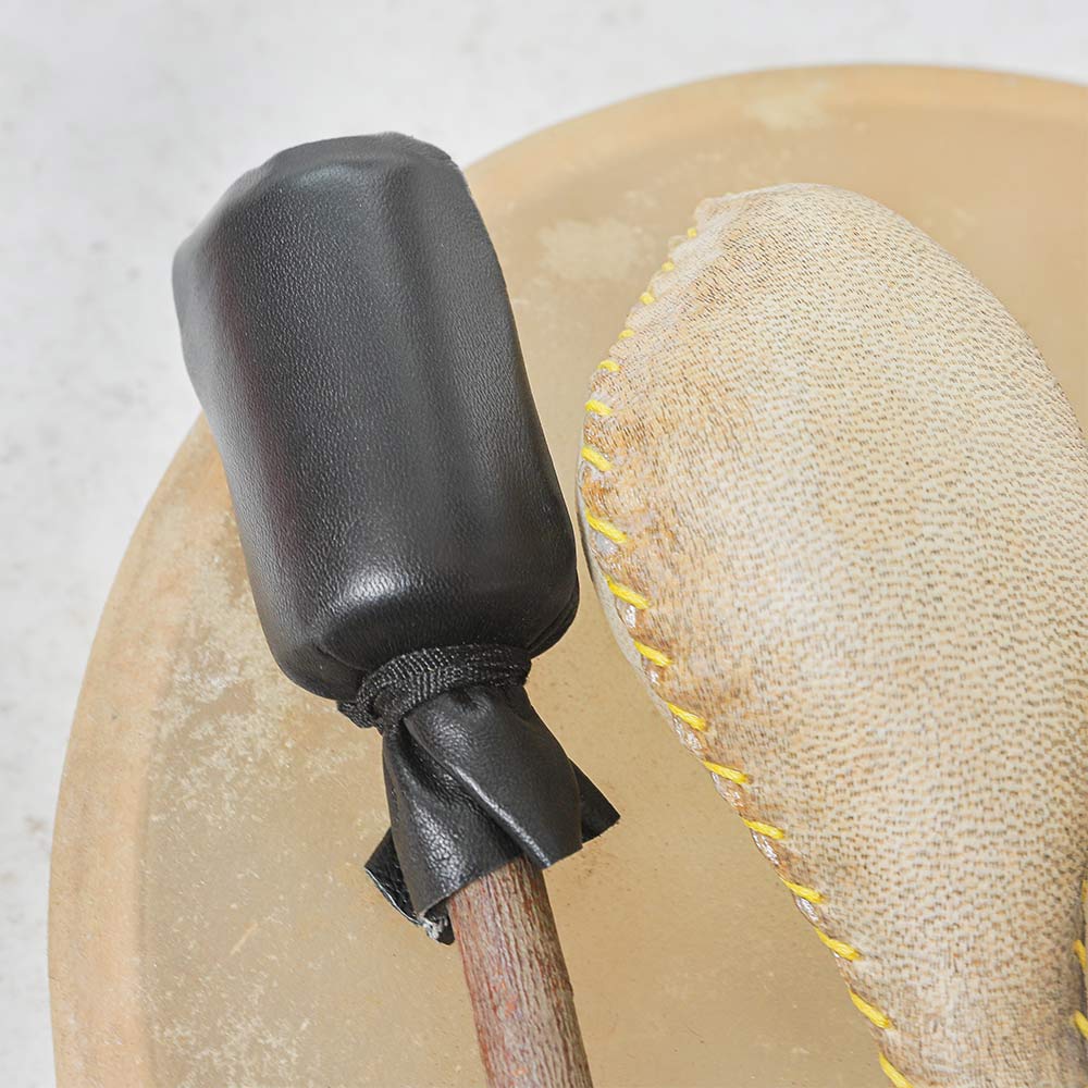 Close up of the shamanic drum beater with black head and terre animal hide shaker on top of the 40cm shamanic khenji drum
