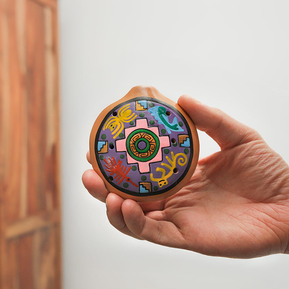 Handheld Nazca Ocarina, handmade from sustainable clay with vibrant hand-painted designs. A unique and beautiful Peruvian woodwind instrument