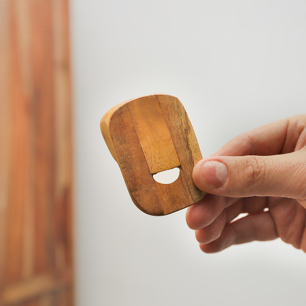 Nose flute held in hand, demonstrating its size and design.