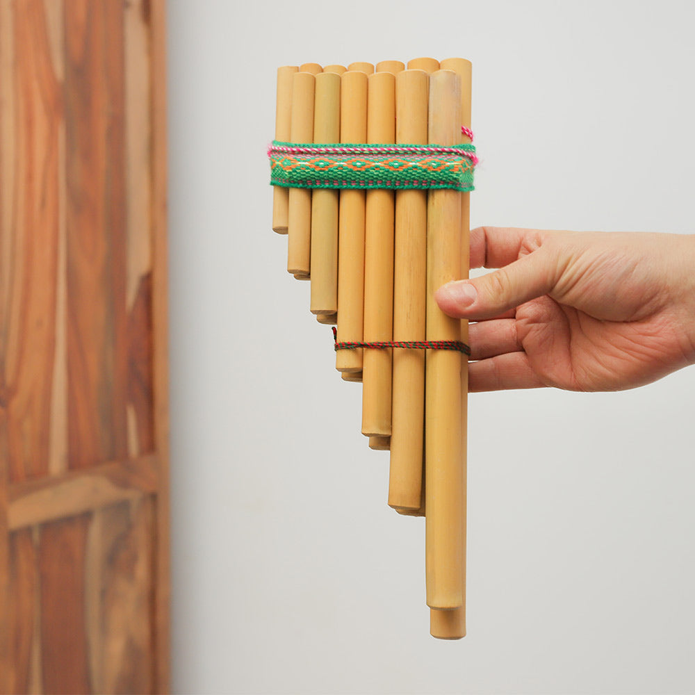 Peruvian bamboo Zampona panpipes held in hand to show size and scale.