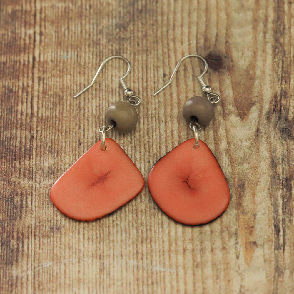 Pink and grey Tagua earrings on a wooden backdrop