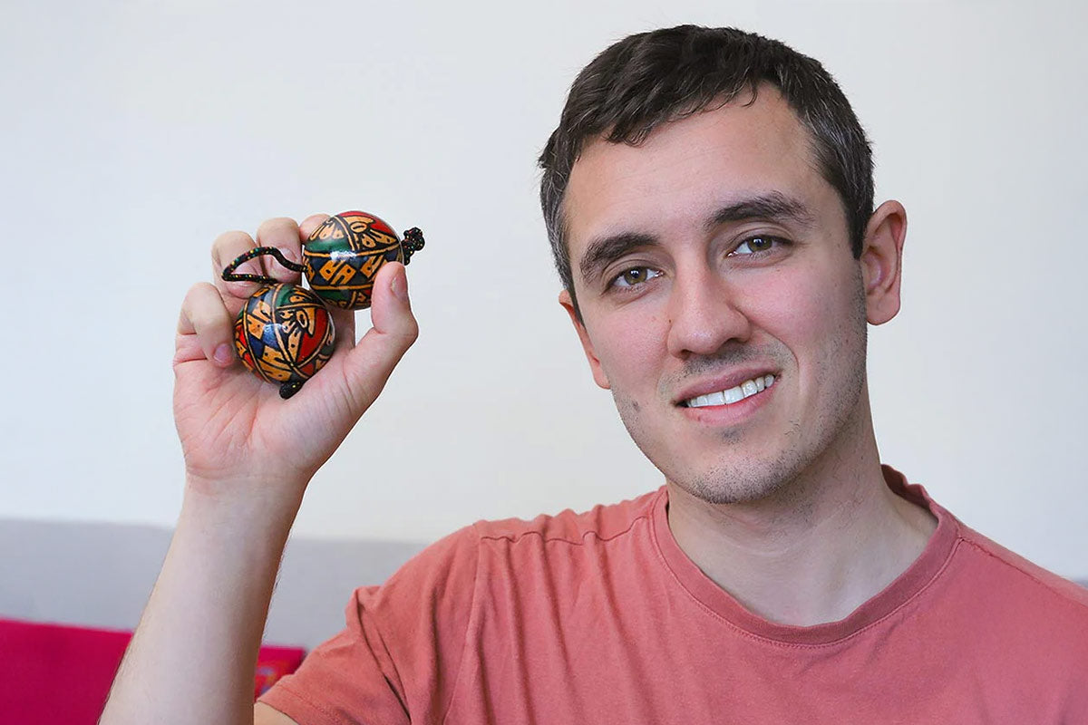 Man holding a colorful object against a plain background