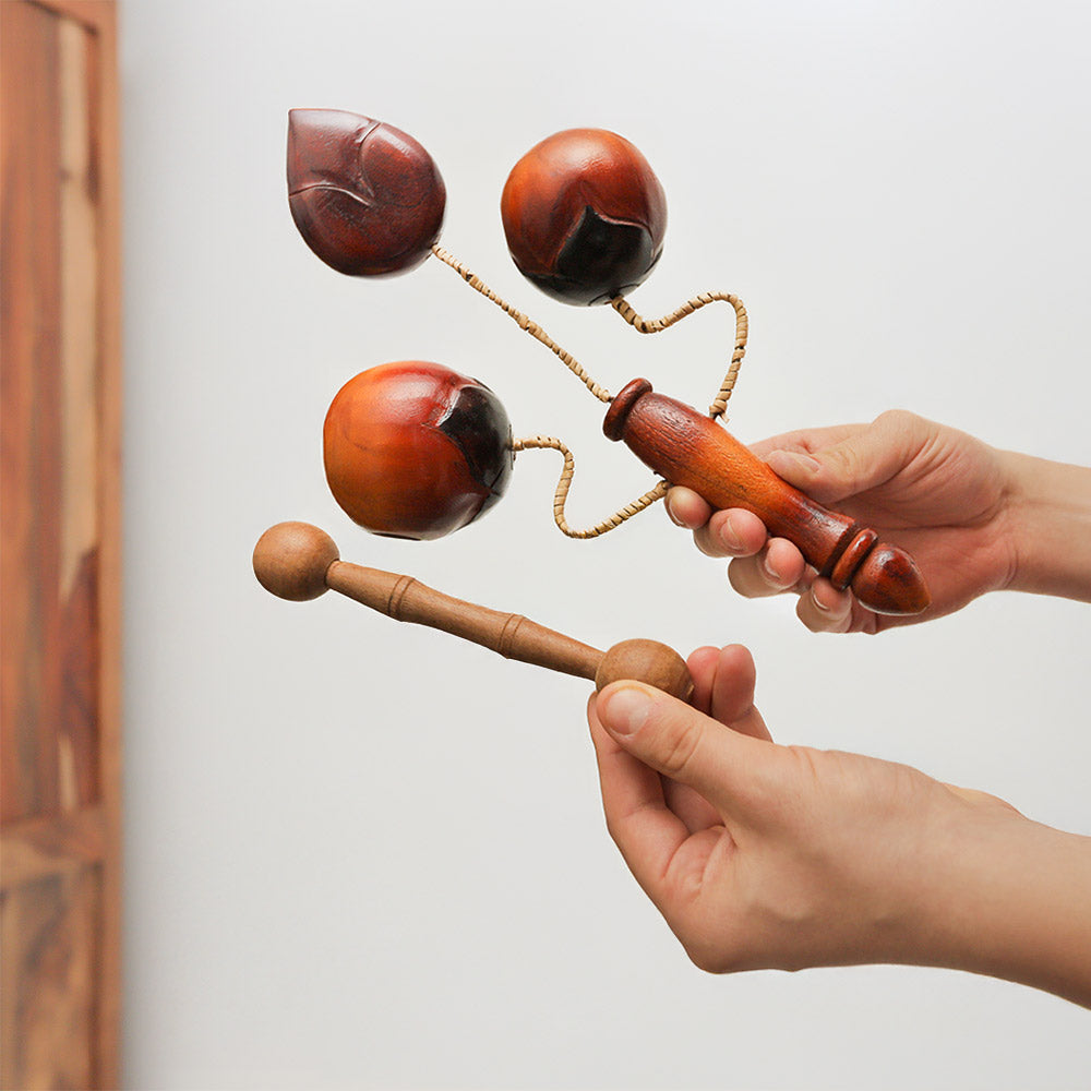 Handheld Vietnamese Lotus Clacker tone block percussion instrument, crafted from wood, produces clear tones when struck.