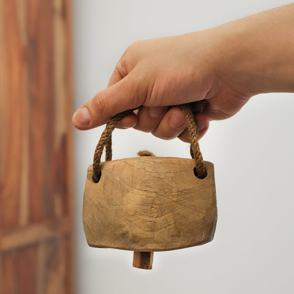 Close up of a cow bell held in the hand, showcasing its size and scale.