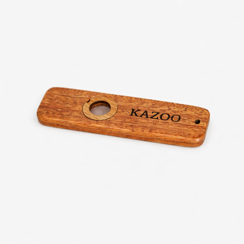 Flat lay wooden kazoo with 'KAZOO' branding on a white background