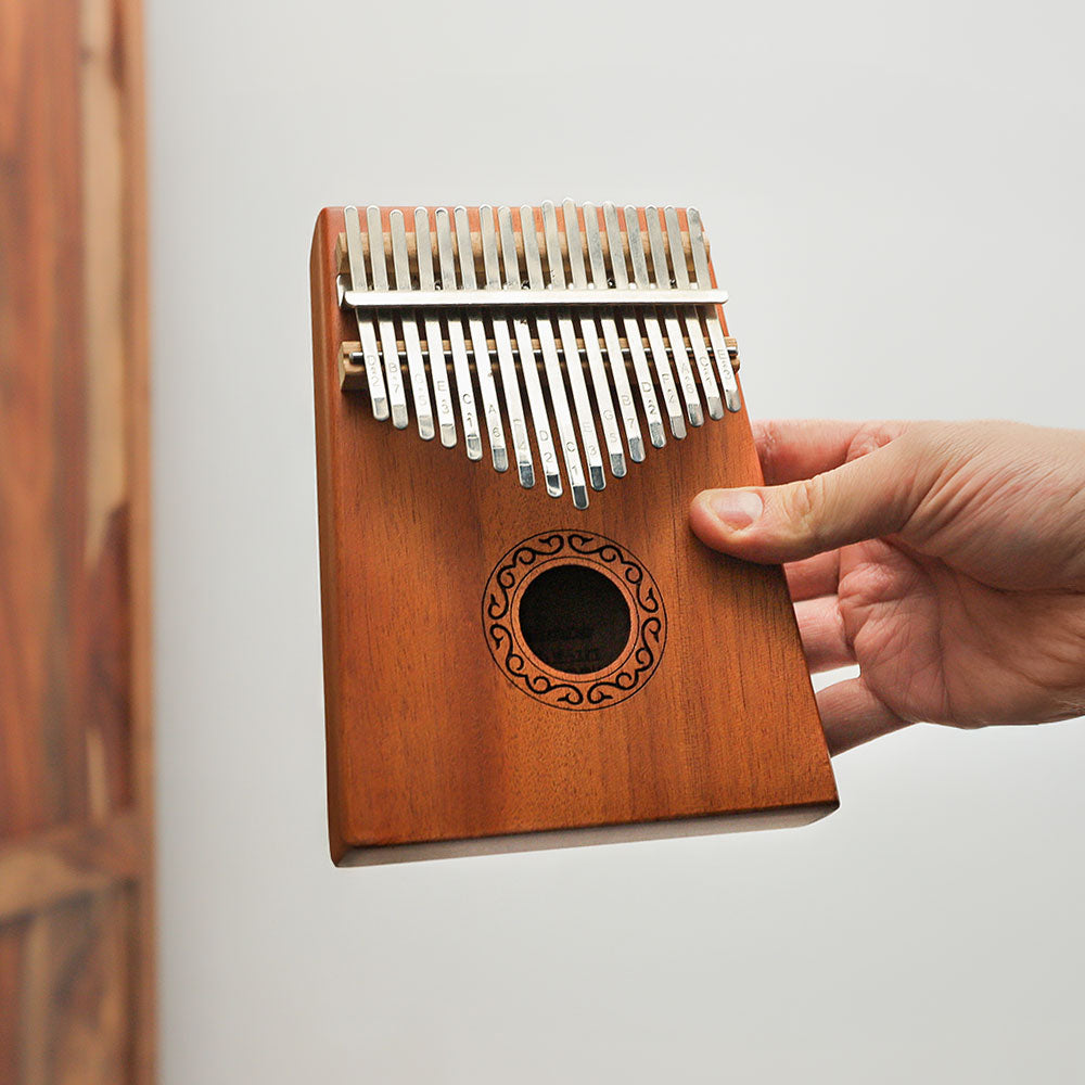 Yulin Kalimba 17 note held in hand, demonstrating its size and design.