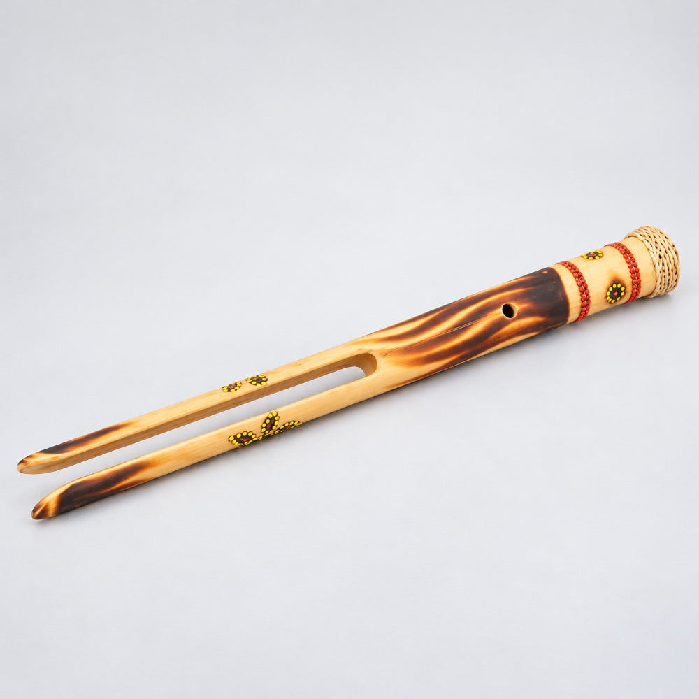 A traditional bamboo boing stick with a natural flame burnished design shown on a light gray background.