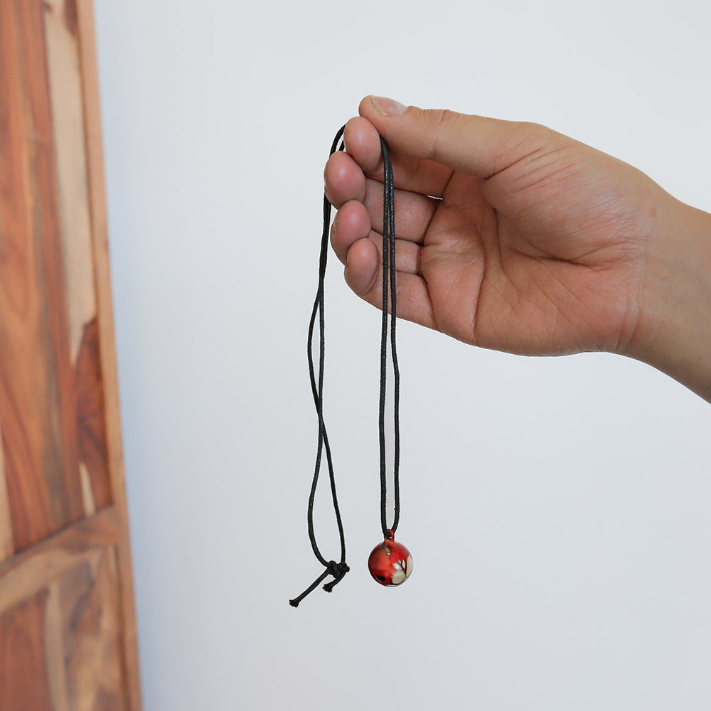 image of bell necklace in hand