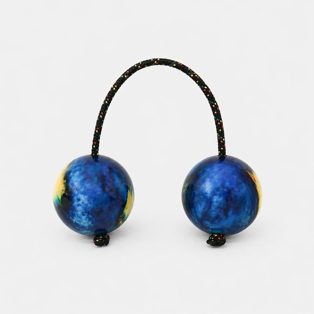 Blue and yellow ocean inspired kashaka shakerwith multcoloured rope on a light grey studio background
