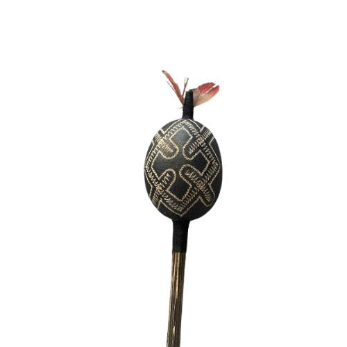 Decorative gourd with a patterned top and wooden handle on a white background