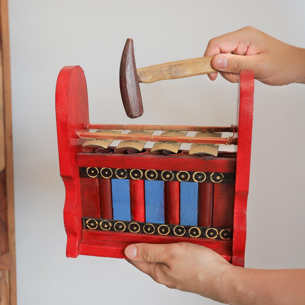 four note gamelan in hand with beater