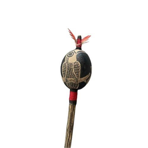 Decorative shipibo maraca with feather on a white background
