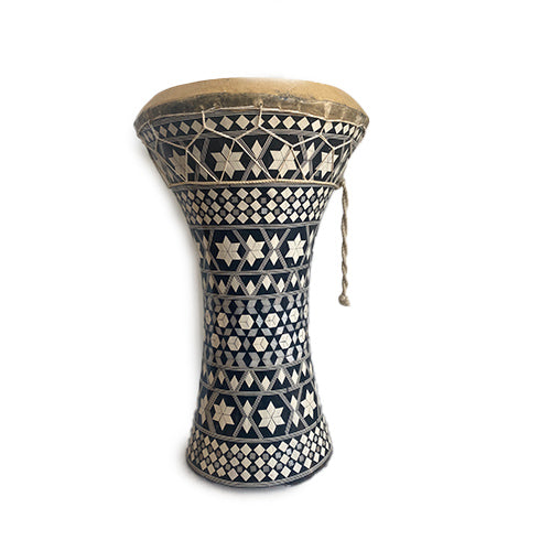 A handmade Egyptian doumbek drum with black and white geometric patterns on the frame and animal hide on the top.