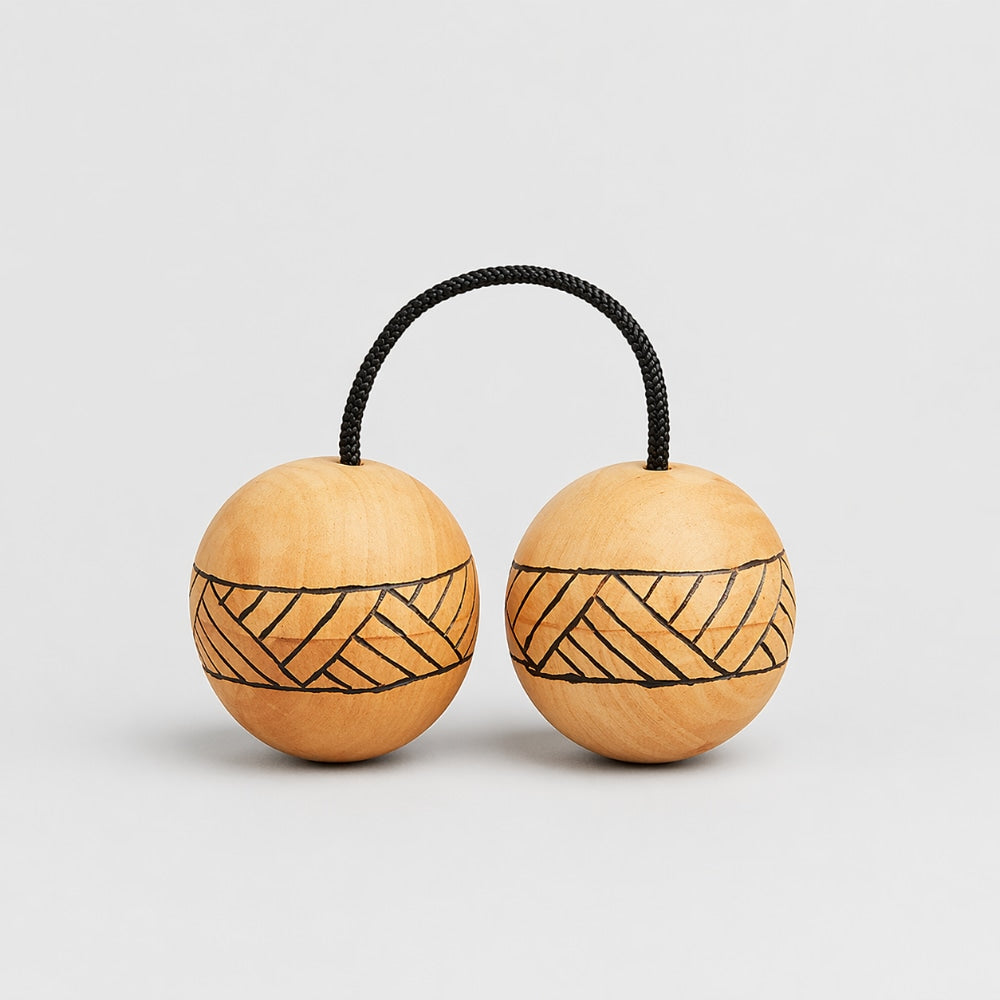 Tribal designed wooden kashaka shaker rattles with geometric patterns on a light gray studio background