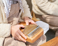 A kid beginner playing a kalimba