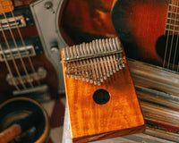 Kalimba musical instrument highlighted with guitars surrounding it.