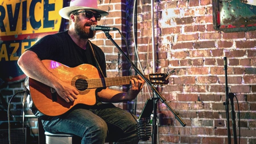 Man Playing Guitar While Singing