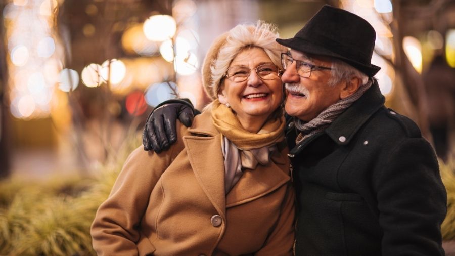 An elderly man and woman embracing and expressing genuine love and affection.