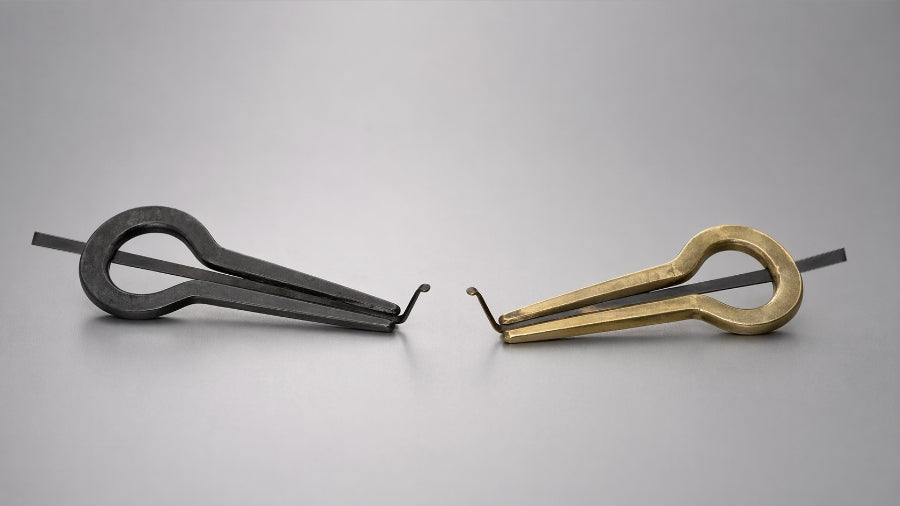 Cast iron and brass jaw harp on grey studio background