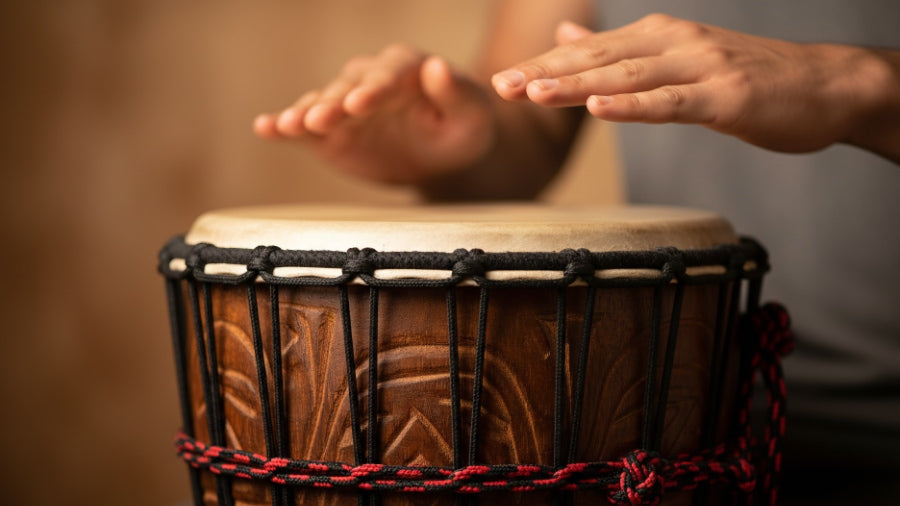 Mans hands about to slap djembe drum