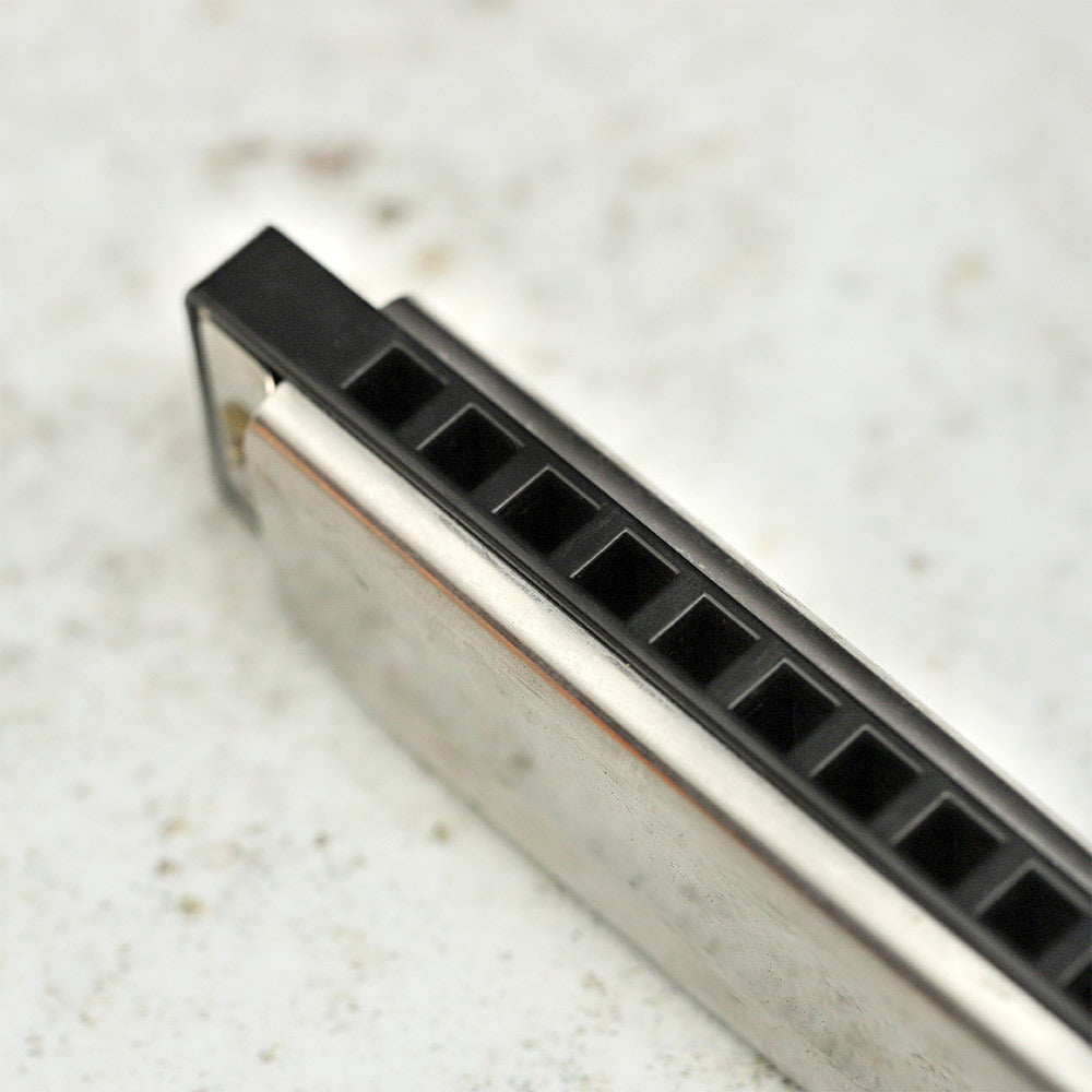 Detailed view of the diatonic harmonica's note holes, showing the numbered slots used for playing different pitches.